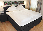 schwarzes Boxspringbett mit weißer Bettwäsche